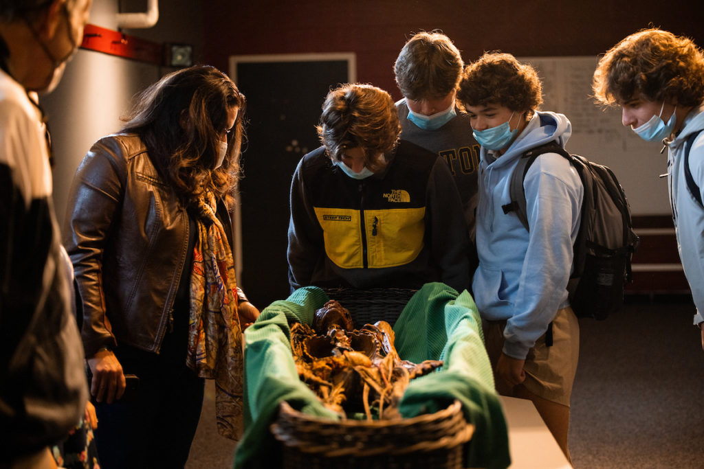 Students and faculty gathered around to view a mummy on Tilton's campus.