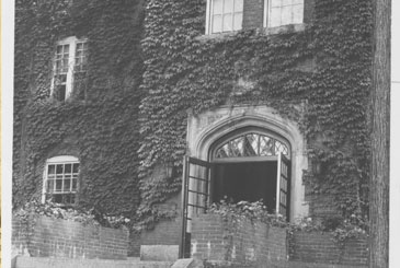 Black and white photo of ivy growing on the front of Knowles Hall