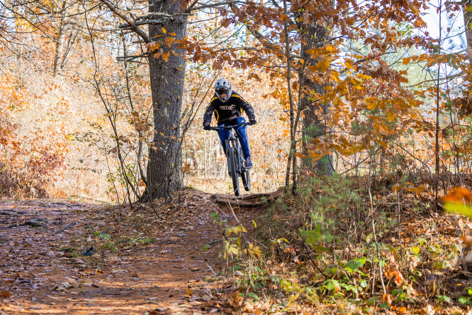 A Tilton student-athlete rides through the woods of a New Hampshire mountain biking course.
